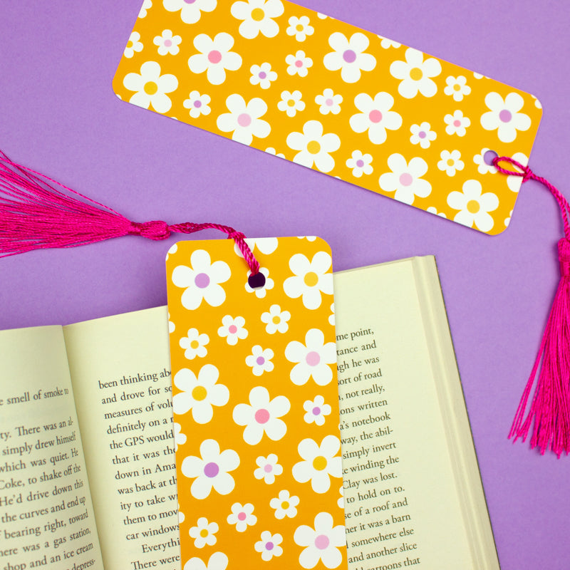 Sprinkle Club - A pastel orange bookmark with a white daisy print and a pink tassel