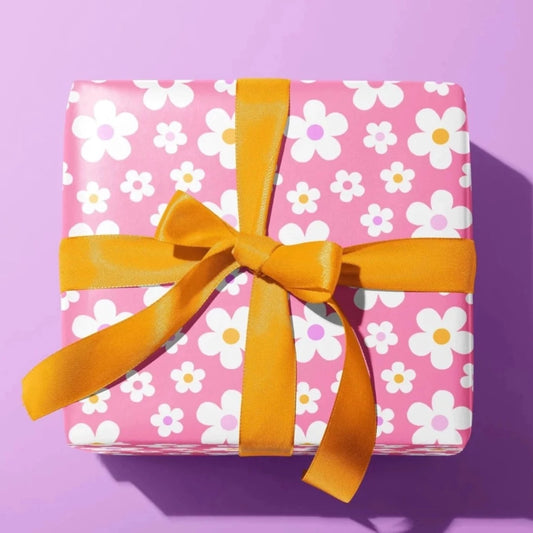 Sprinkle Club - A present wrapped in baby pink wrapping paper with a white daisy flower pattern