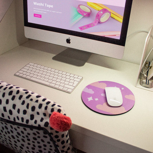 Sprinkle Club - A minimalist desk with an iMac, purple and pink kawaii mouse mat, a keyboard and a spotty cushion