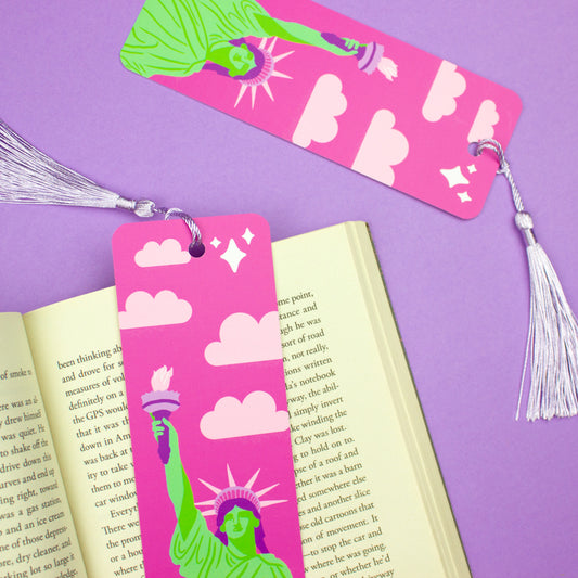 Sprinkle Club - A pink bookmark with the Statue of Liberty illustration and clouds, accompanied by a lilac tassel
