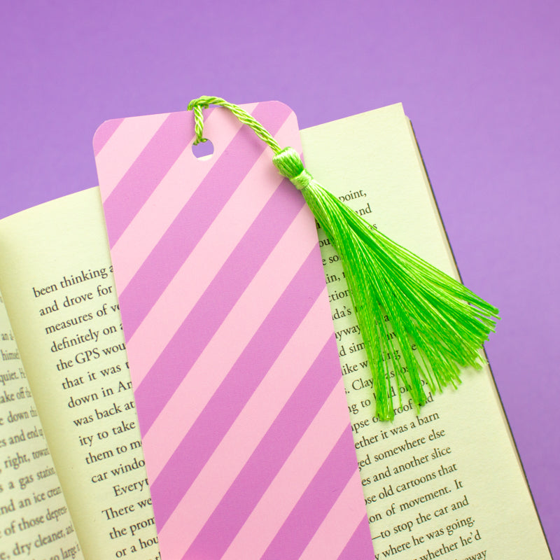 Sprinkle Club - A bookmark with pink and purple diagonal candy stripes and a bright green tassel
