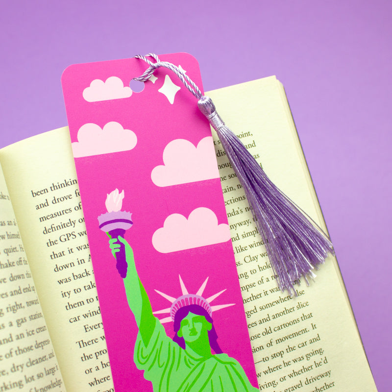 Sprinkle Club - A pink bookmark with the Statue of Liberty illustration and clouds, accompanied by a lilac tassel