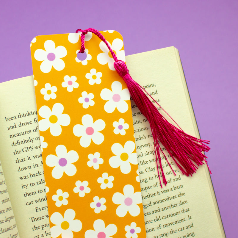 Sprinkle Club - A pastel orange bookmark with a white daisy print and a pink tassel