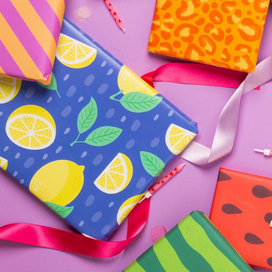Sprinkle Club - A gift wrapped in blue wrapping paper with a zesty lemon print design