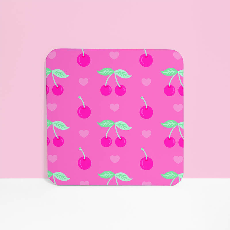 Sprinkle Club - A single pink square drinks coaster with a playful pattern of cherries and hearts