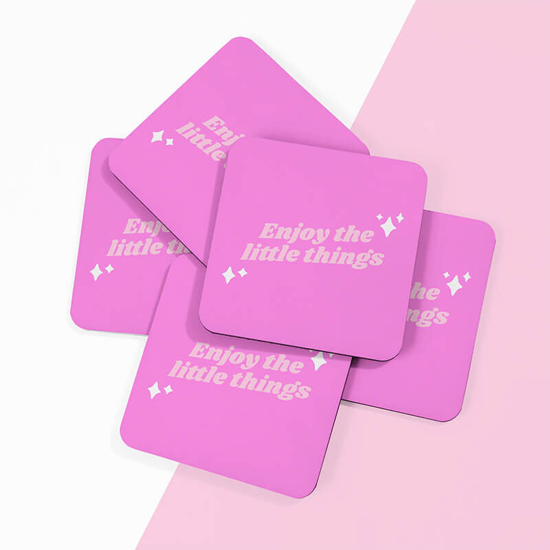 Sprinkle Club - Multiple vibrant pink square coasters with 'Enjoy the little things' in playful light pink lettering, spread out on a soft pink background with a slight shadow
