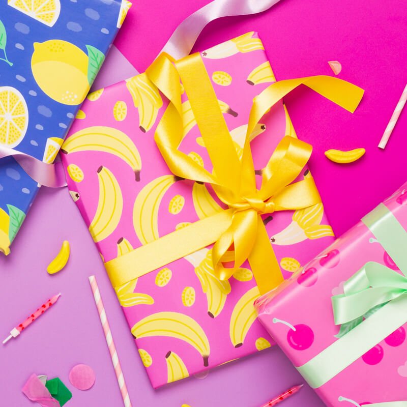 Sprinkle Club - Pink and yellow banana themed wrapping paper with a yellow ribbon