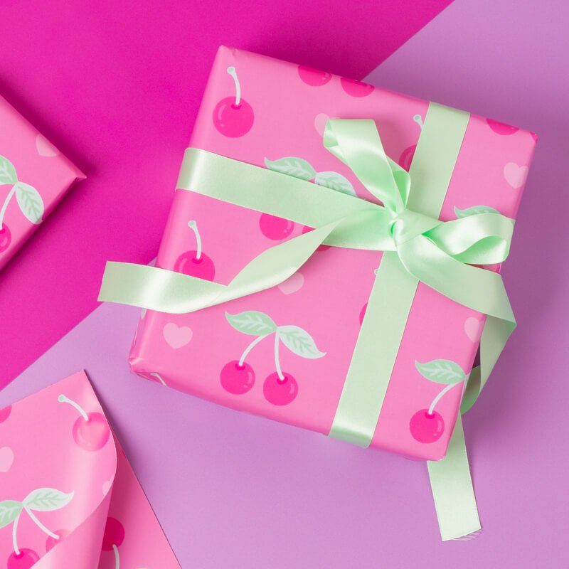 Sprinkle Club - A Valentine's day gift wrapped in pink wrapping paper with a cherry and heart design and a ribbon