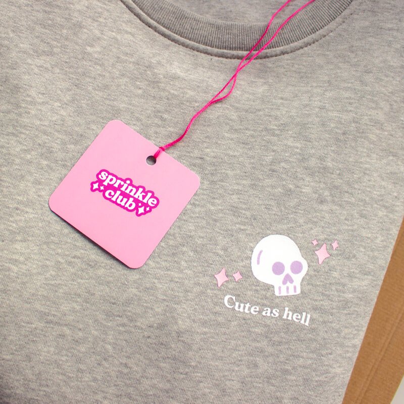 Sprinkle Club - A close up of a women's grey halloween themed sweatshirt with a cute skull illustration