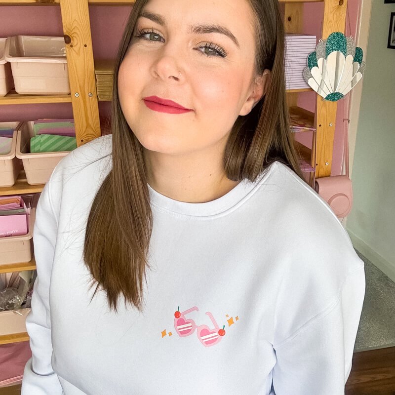 Sprinkle Club - A woman smiling and wearing a white and pink valentine's sweatshirt