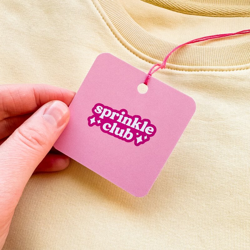 Sprinkle Club - A pink swing tag for a valentine's inspired yellow sweatshirt