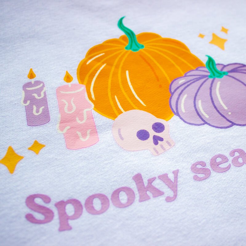 Sprinkle Club - A close up of a bright and colourful halloween illustration on a white sweatshirt