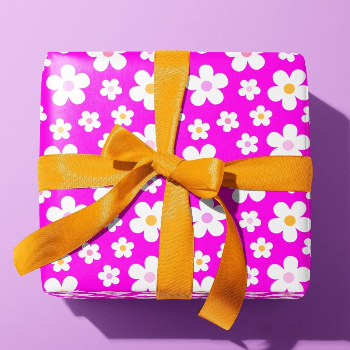 Sprinkle Club - A gift wrapped in bright hot pink wrapping paper with a cute daisy pattern