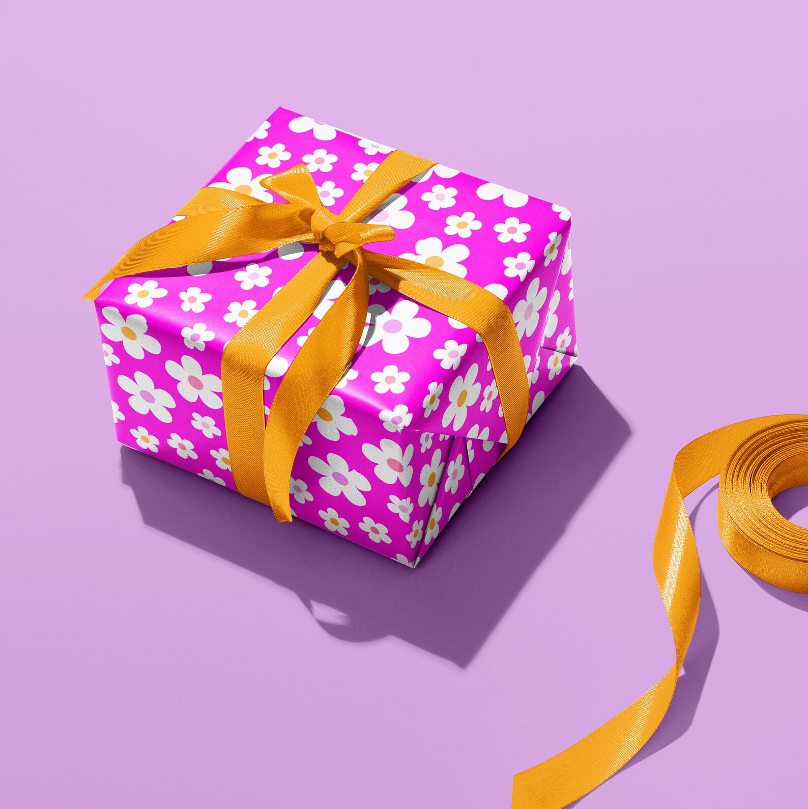 Sprinkle Club - A gift wrapped in pink daisy wrapping paper and tied with a orange ribbon