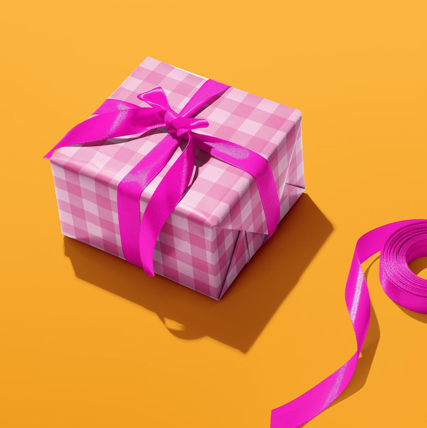Sprinkle Club - A present wrapped in pink gingham print wrapping paper with a hot pink bow