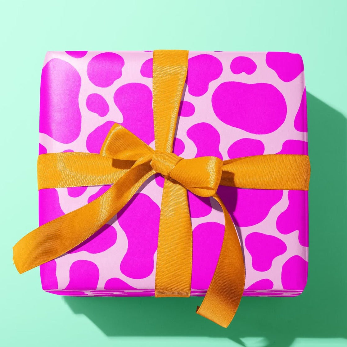Sprinkle Club - A gift wrapped in pink cow print wrapping paper