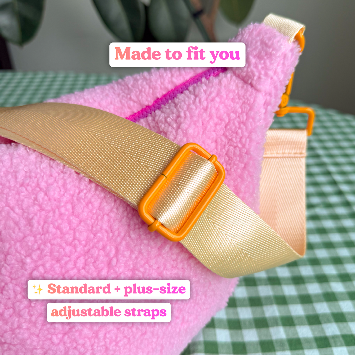 Close-up of the pastel yellow adjustable strap with an orange slider buckle on the pink fluffy teddy crossbody bag, with text reading "Made to fit you: standard and plus-size adjustable straps"