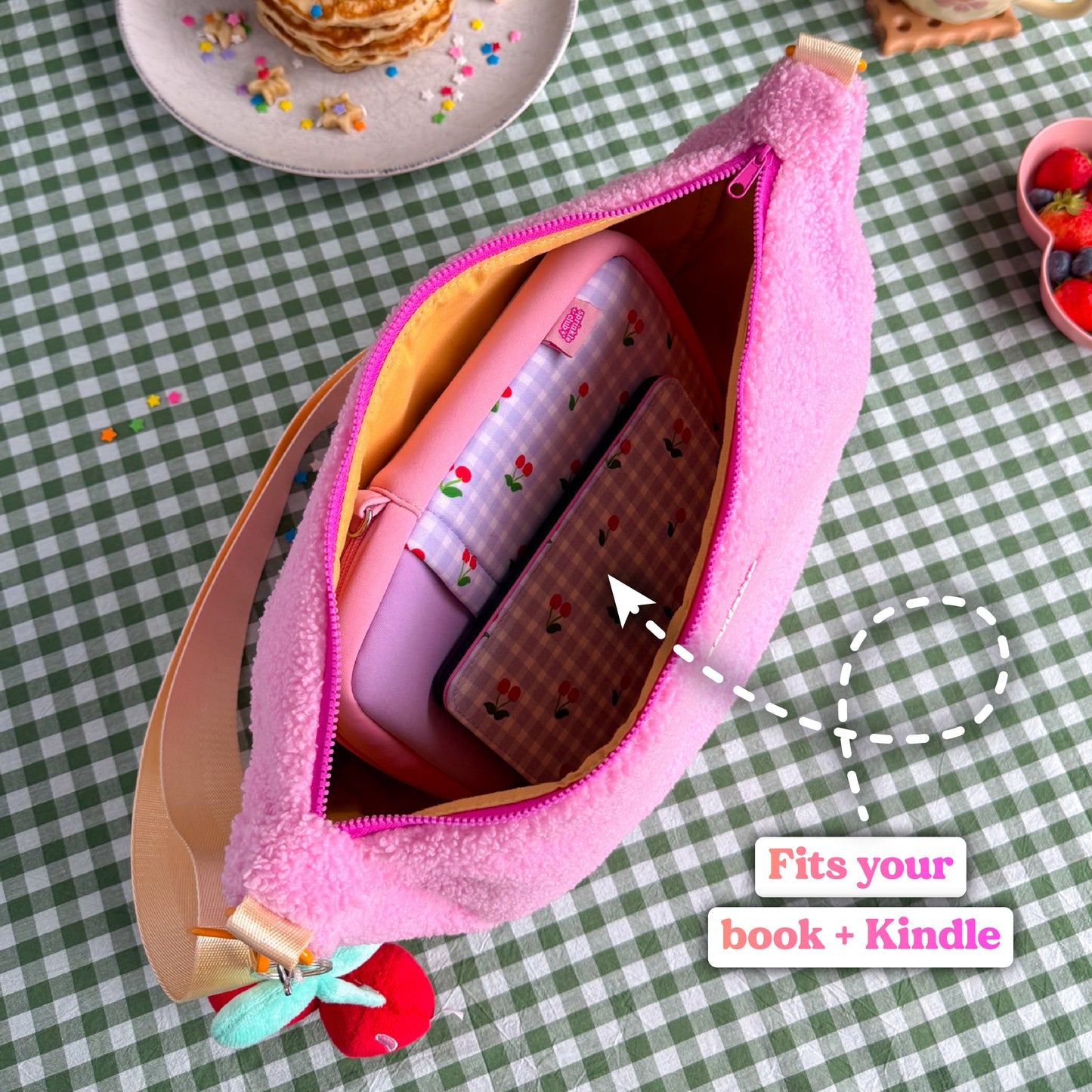 Pink teddy crossbody bag open to show a book in a book sleeve and Kindle fitting inside